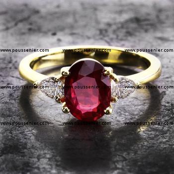 trilogy ring met een ovale robijn waarnaast twee peer geslepen diamanten gezet met scheensteunpuntgriffen