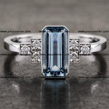 ring met een lange strak smaragd geslepen aquamrarijn waarnaast trapsgewijs briljant geslepen diamantjes en afgewerkt met milgrain