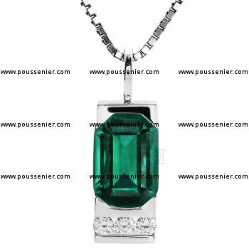 handmade slim pendant set with an emerald cut emerald with slank corners and below three brilliant cut channel set diamonds.