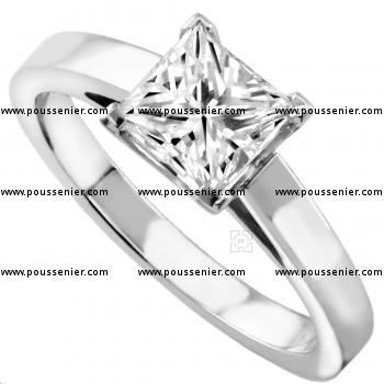 solitaire ring with a princess cut diamond set in a setting with four square cornered prongs on a slim band with palmets