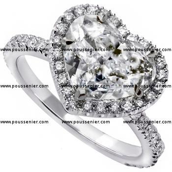 entourage ring with a central heart cut diamond in dropshaped claws and accent stones pavé set around and on the band