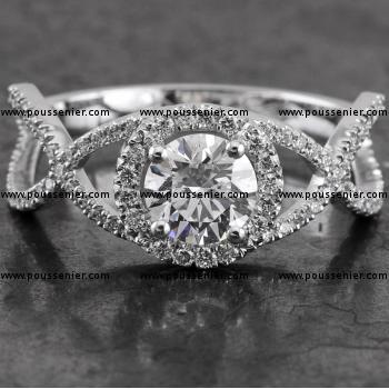 entourage ring met een briljant geslepen diamant omringd met kleine briljantjes bovenop een gevlochten band eveneens met kasteelzetting