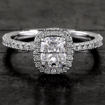 entourage ring with a central cushion cut diamond surrounded by castle-set brilliants mounted on a bird-shaped hollow V with an american set diamond and integrated into a set band (wearable together with a wedding ring)