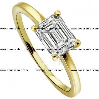 solitaire ring with an emerald cut diamond low set in the same direction as the band in four curved prongs without middlering on a tightly narrowed slightly rounded finished and slightly sloping band