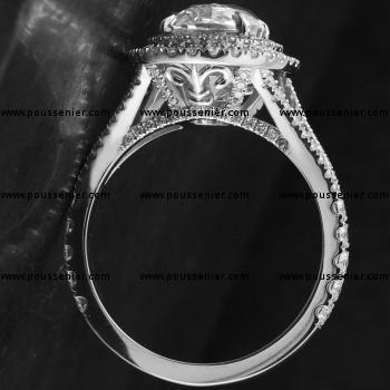double halo ring or entourage ring with an oval cut diamond surrounded by smaller brilliant cut diamonds mounted on a split band with integrated logo