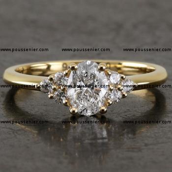 handgemaakte ring met een ovale diamant waarnaast drie briljant geslepen diamantjes gezet met grifjes