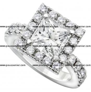 entourage ring with a central princess cut diamond lower on a band with smaller brilliant cut diamonds
