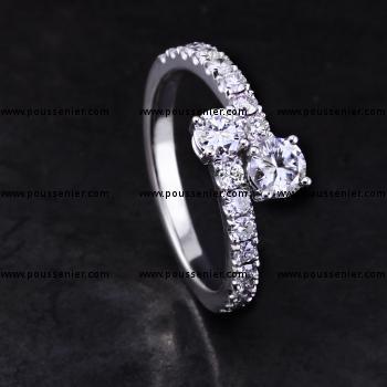 Toi et Moi ring met twee briljant geslepen diamaten vast tegen elkaar met de band kasteel bezet met kleinere diamanten