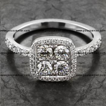 halo ring with four central brilliant cut diamond surrounded by a cushion shaped castle set halo and also diamonds on the band
