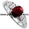 elegant and fine trilogy ring with an oval ruby flanked by two pear shaped diamonds set with claws