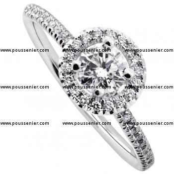 halo ring with a brilliant cut diamond with and smaller diamonds set around and on a rounded shank or curved band