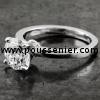 handmade solitaire ring with a larger central brilliant-cut diamond with four clean-cut prongs on an unset slim band or shank with a rectangular profile 