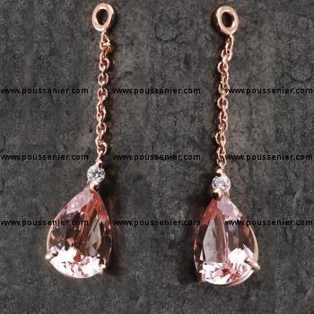 pair of handmade pendants with a pear-cut morganite/Beryl set with three fine claws above which a brilliant-cut diamond dangles from a chain and can be worn together with solitaire earrings
