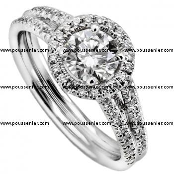 entourage or halo ring with a larger central brilliant cut diamond with the sides pavée castle set with smaller diamonds