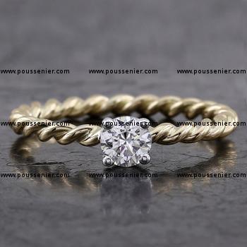 twisted ring made with twisted golden wire with a brilliant cut diamond set in four prongs