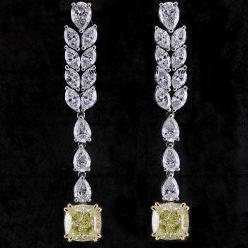 long elegant earrings with fancy yellow cushion cut diamonds above which pear-shaped and marquise cut diamonds all set with prongs or claws