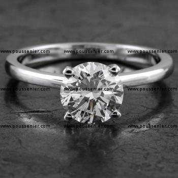 solitaire ring with a brilliant cut diamond lower set in four prongs on a tight narrower band
