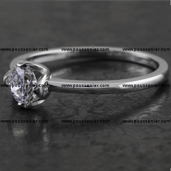 Handmade solitaire ring with a brilliant-cut diamond with four lotus leaf shaped prongs as low as possible on a thin rounded band