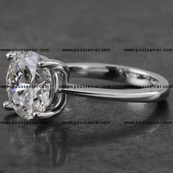 handmade solitaire ring with a brilliant cut diamond set with four prongs between which a single roundel mounted on a convex shank up to the top