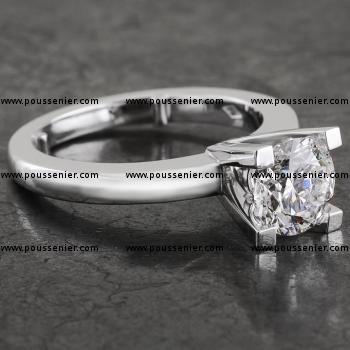 solitaire ring with a brilliant cut diamond set high with four square prongs on a smaller band, rounded at the top, with two slats against turning