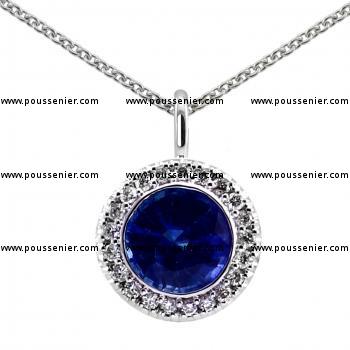 entourage or halo pendant with a central round sapphire around which pavé set diamonds finished with an engraving and mounted on an oval bracket
