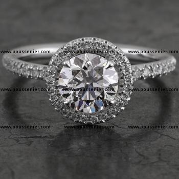 halo ring with a central brilliant cut diamond on a fine round band set with smaller diamonds