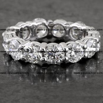 eternity ring set with larger brilliant cut diamonds set with two prongs between two diamonds mounted against double rondelles