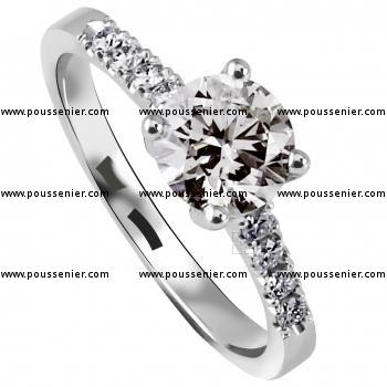 solitaire ring with a brilliant cut diamond and smaller castle set diamonds on the side on a slightly smaller band