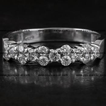 alliance ring with brilliant cut diamonds set in pairs next to a slightly larger diamond with two prongs between each two diamonds