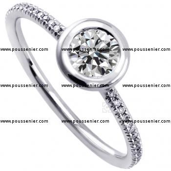 solitaire ring with a brilliant cut diamond set in a donut with a thin border mounted on a round thin band with two rods and set with smaller brilliant cut diamonds