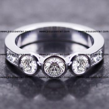 trilogy ring with three brilliant cut diamonds set in a round bezel settings and flanked by two princess cut diamonds on each side