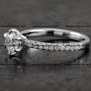 Handmade solitaire ring with a brilliant cut diamond set in 6 prongs rounded setting made of round wire and the band set with smaller brilliants.