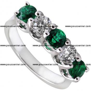 handmade complex anniversary ring with larger brilliant cut diamonds and emeralds set with two prongs between each two diamonds on double roundels