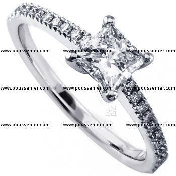 solitaire ring with a central princess cut diamond with smaller castle set diamonds on the band