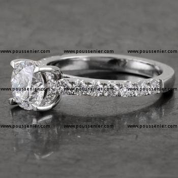 engagement ring with a brilliant cut diamond set slightly higher in four rounded prongs with roundel and band palmettes castle set (can be worn together with wedding ring)