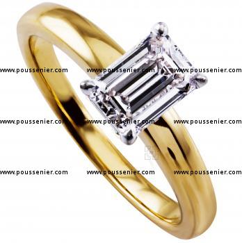 solitairering with an emerald cut diamond lower set in four prongs on a rounded band