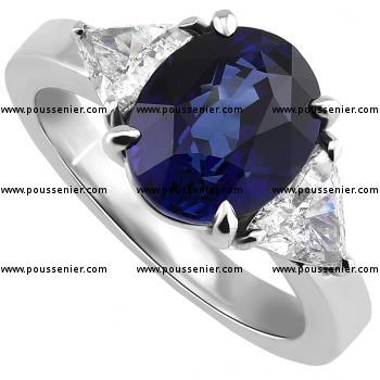 ring met een ovaal geslepen saffier waarnaast twee triangle geslepen diamamanten op een strakkere band met zeer lichtbollig profiel