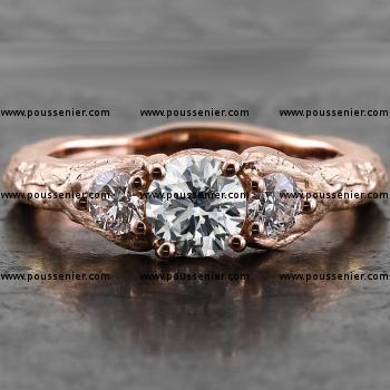 organisch ogende ring met een grotere centrale briljant geslepen diamant geflankeerd door twee kleinere briljanten