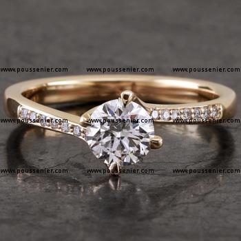 handmade solitaire ring with a brilliant cut diamond in a twisted setting with four prongs and the sides set with smaller diamonds