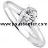 solitaire ring with a pear shaped diamond set in prongs between a band with palmettes