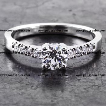 solitaire ring with a brilliant cut diamond and smaller castle set diamonds on the side