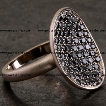 pavé ring with a concave asymmetric disc or bowl with pavé set with black irradiated brilliant cut diamonds mounted on a narrow band