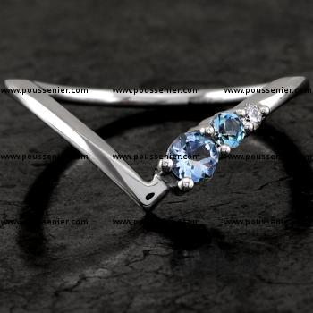 bird ring with a curved V shape, a brilliant cut diamond and two brilliant cut aquamarines set with prongs to match a larger engagement ring 
