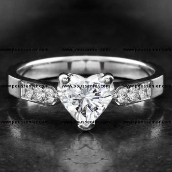 solitairering voor hartgeslepen diamant met briljant geslepen diamanten opzij afgewerkt met filet of gravure