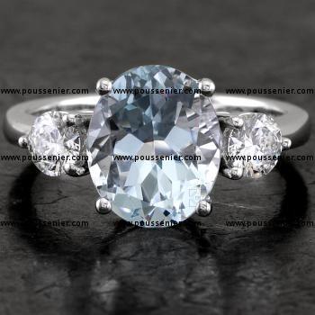 trilogy ring with an oval cut aquamarin flanked by two brilliant cut diamonds all set with prongs or claws