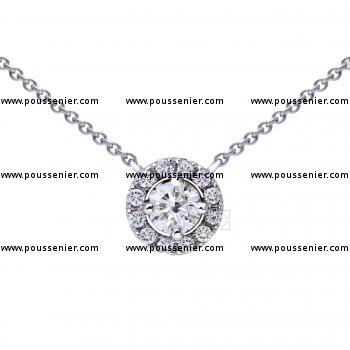 necklace entourage pendant with a larger central brilliant cut diamond set with four prongs and surrounded by smaller diamonds
