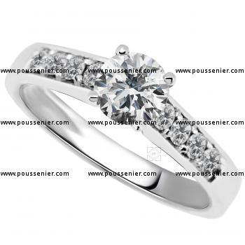 solitaire ring with a larger central brilliant cut diamond and pavé set smaller diamonds aside