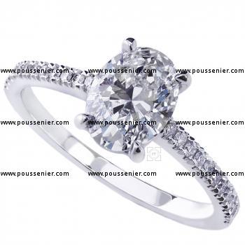 solitaire ring with a central oval cut diamond with smaller diamonds on the side castle setted a thinner band