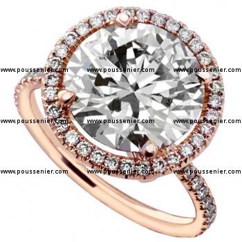 entourage ring with a larger central brilliant cut diamond on a fine round band set with smaller diamonds