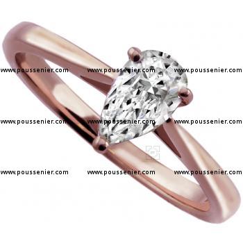 solitaire ring with a teardrop or pear shaped diamond set with four rounded claws on a badn with palmets on the side